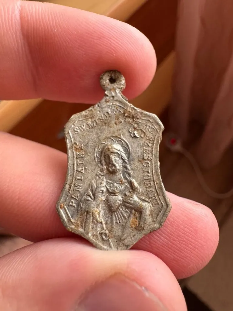 Original photo of the found medallion in a hand
